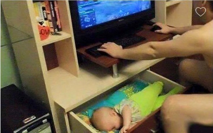 hombre en la computadora con su bebé dormido dentro de un cajón 