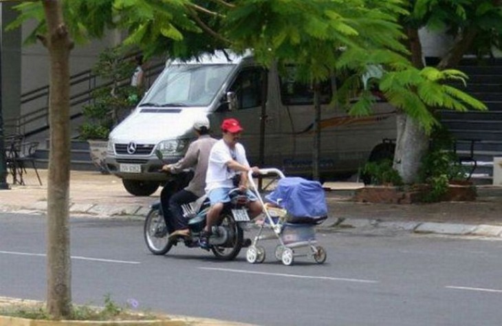 hombre sobre una moto paseando a su bebé en su carreola