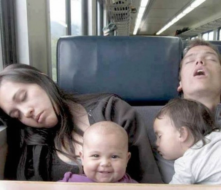 fotografía de dos padres dormidos con su hijas en un autobús 
