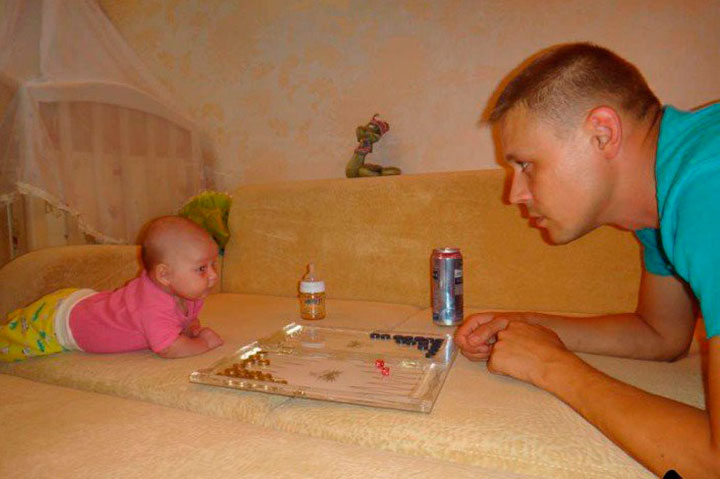hombre frente a su hija con un juego de mesa entre ellos 