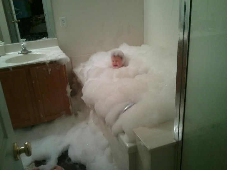 bebé llorando dentro de una bañera llena de espuma 