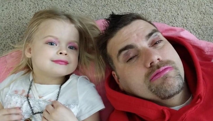 padre maquillado a un lado de su pequeña hija 