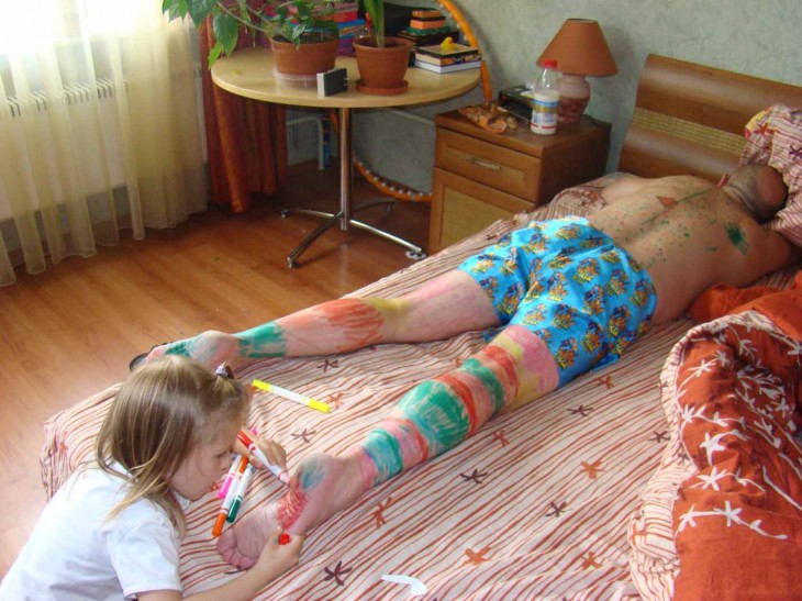niña pintando a su papá mientras duerme 