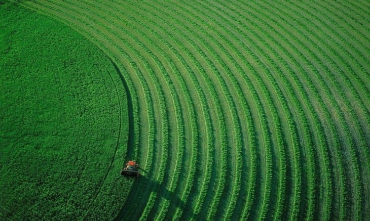 tractor recorriendo unos pastos verdes con círculos 
