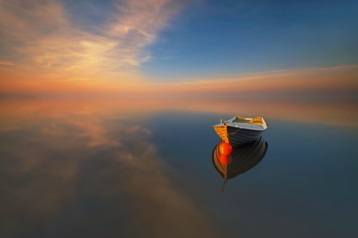 imagen de una barca sobre un mar en un atardecer 