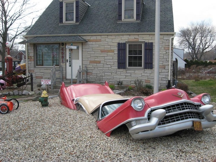 un coche sumergido en la parte delantera de una casa 