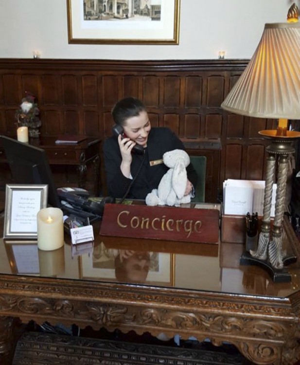 Conserje del hotel Adare Manor en Irlanda con un conejo de peluche en su mano 