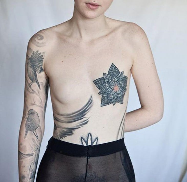 cuerpo de una mujer con tatuajes en sus senos 