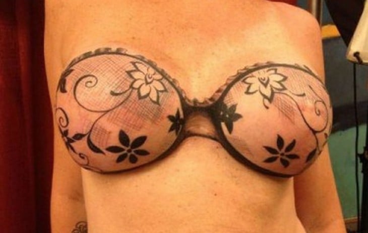 fotografía del tatuaje en forma de sujetador de encaje sobre los pechos de una mujer 