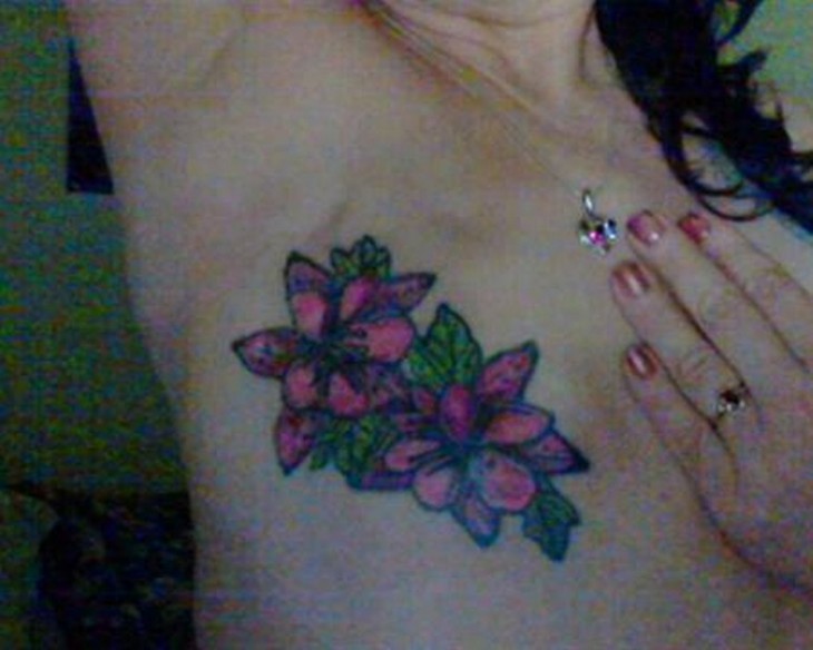Tatuaje de dos flores sobre las cicatrices del pecho de una mujer que padeció cáncer de mama 
