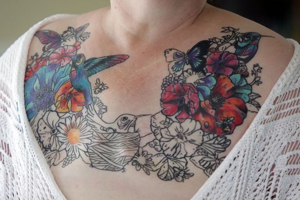 Tatuaje de flores y pájaros sobre el pecho de una sobreviviente al cáncer de mama 