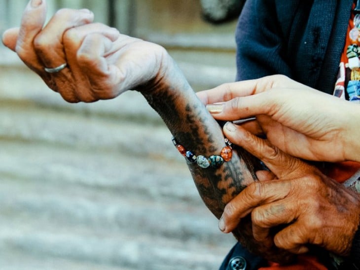 Whang-do mostrando los tatuajes que tiene en una mano 