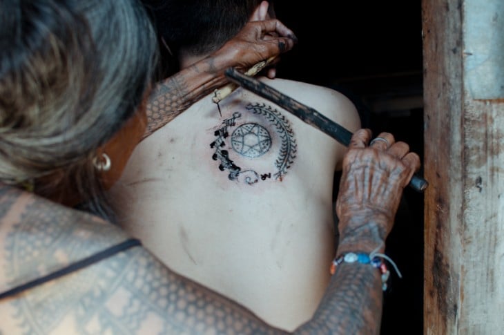 Whang-do tatuando a una persona con la técnica tradicional 