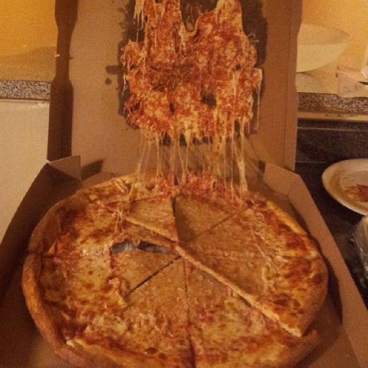 pizza que se quedo embarrada en la tapadera de la caja