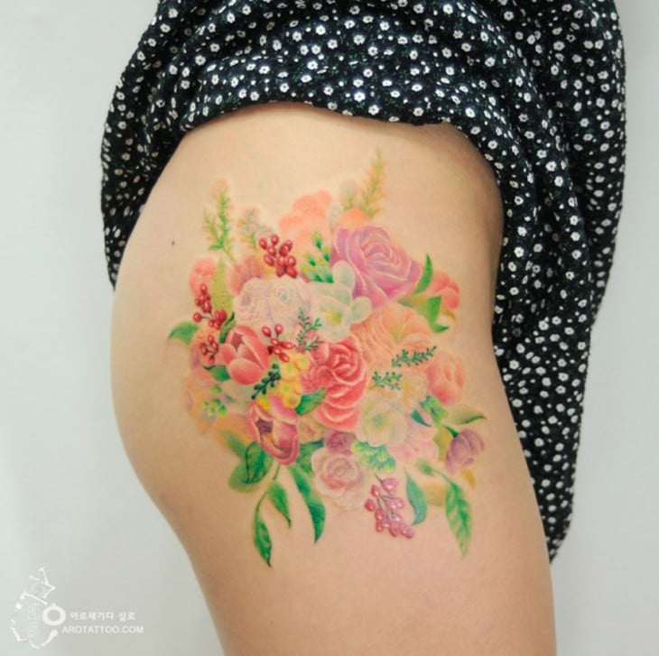 tatuaje acuarela con un diseño floral sobre un muslo 