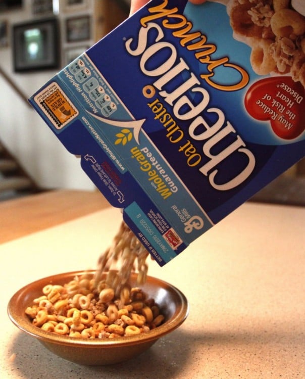 mano de una persona vaciando cereal sobre un plato 