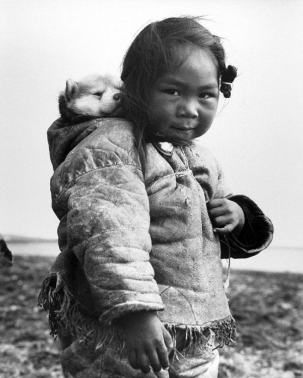 NIÑA ESQUIMAL JUNTO A SU CACHORRO PASEANDO POR LA CIUDAD