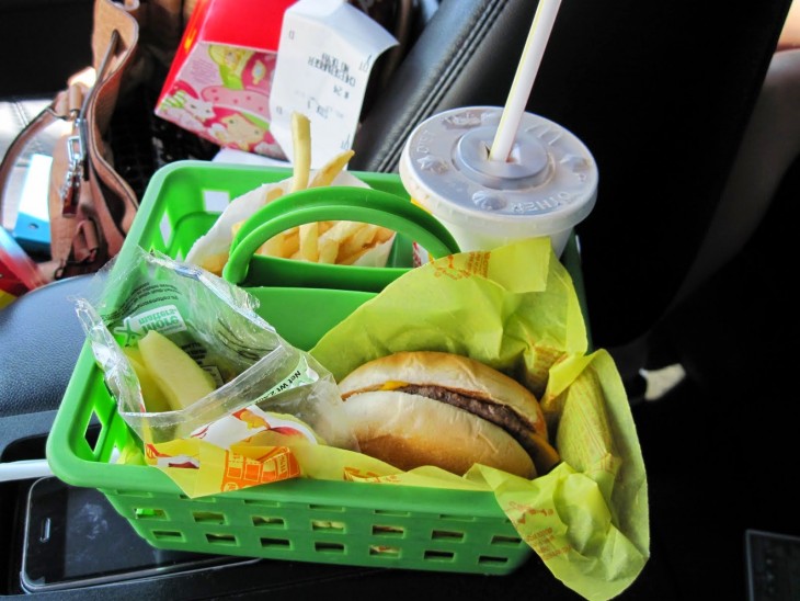 comida rápida organizada en una cesta de plástico dentro de un coche 