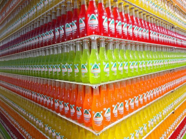 Botellas de vidrio de jarritos acomodadas por colores y sabores 