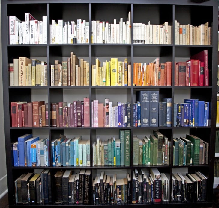 Librero lleno de libros ordenados por tamaños y colores 