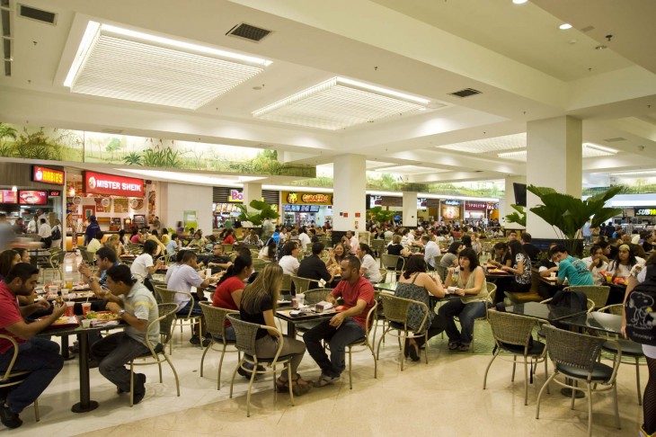 personas comiendo en el área de comida en un centro comercial 