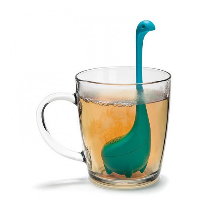 Infusor de té inspirado en el monstruo del lago Ness sobre una taza de vidrio transparente 