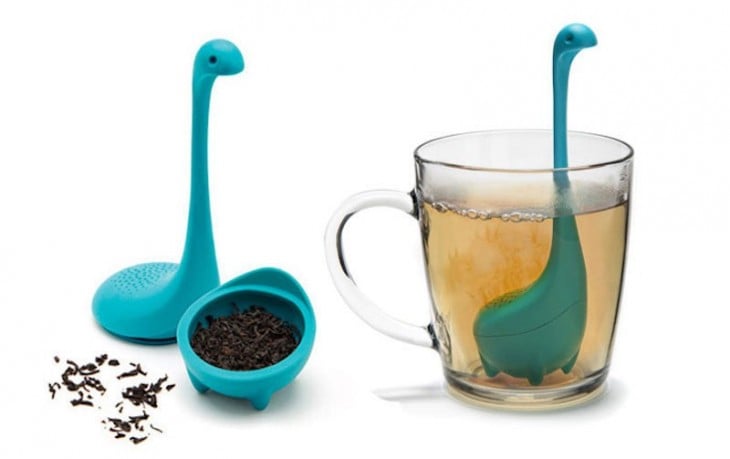 infusor de té del monstruo ness abierto a la mitad y dentro de una taza tranparente 