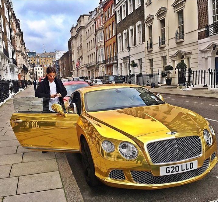 chico rico a punto de subirse a un lujoso coche en una de las calles de Londres 
