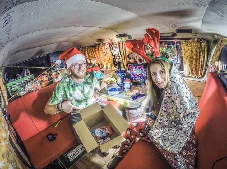 Pareja de Bloggers dentro de una furgoneta vestidos celebrando la navidad 