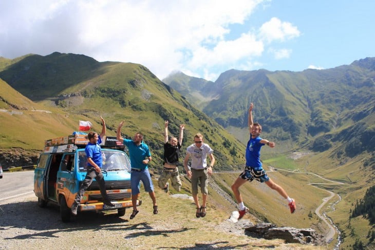 chicos saltando frente a la furgoneta que ha viajado más de 50 países 