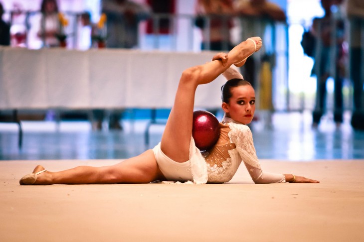 chica gimnasta realizando su número dentro de una competencia 