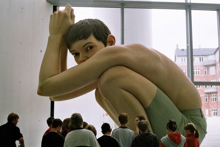 Escultura gigante de un chico sentado a cargo del artista Ron Mueck 