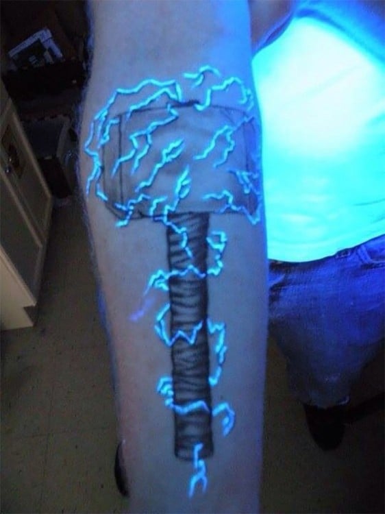 Tatuaje ultravioleta en un brazo con la forma del martillo de Thor 