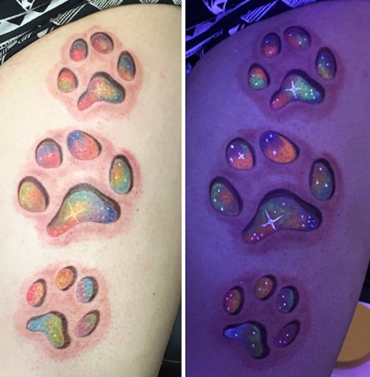 tatuaje que brilla bajo la luz negra con el diseño de las huellas de un perro 
