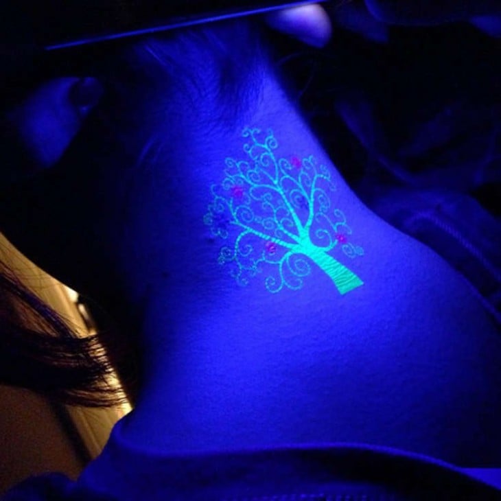 tatuaje ultravioleta con el diseño de un árbol sobre la nuca de una persona 