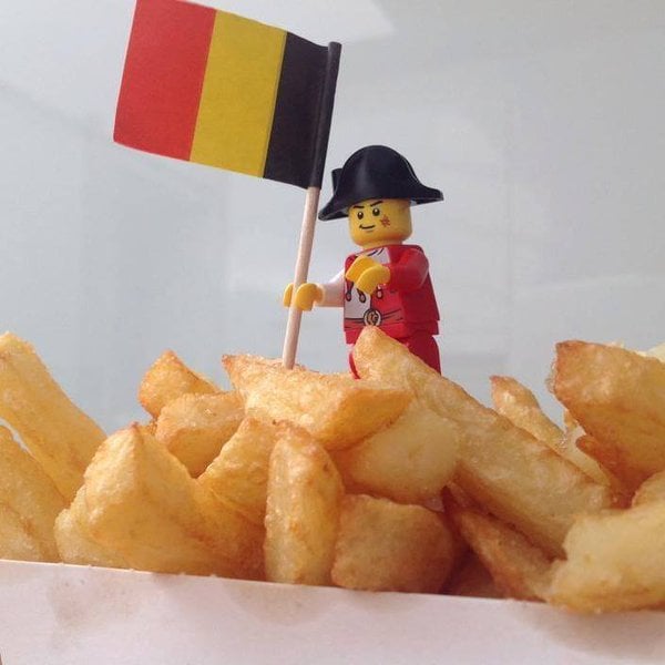 muñeco lego con una bandera de Bélgica sobre unas papas fritas 