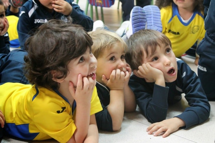 Niños acostado en el suelo escuchando asombrados 