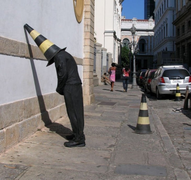 Impresionantes esculturas callejeras de Mark Jenkins de una persona recargada en una pared 