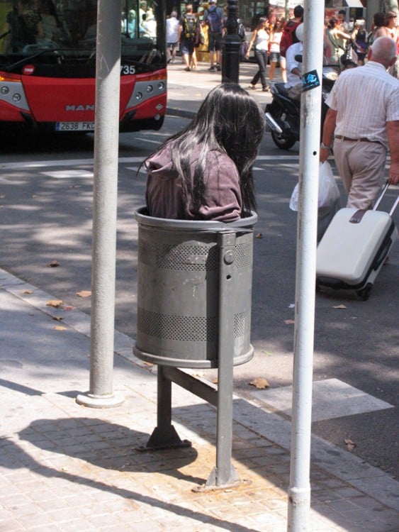 escultura real dentro de un bote de basura en la calle 