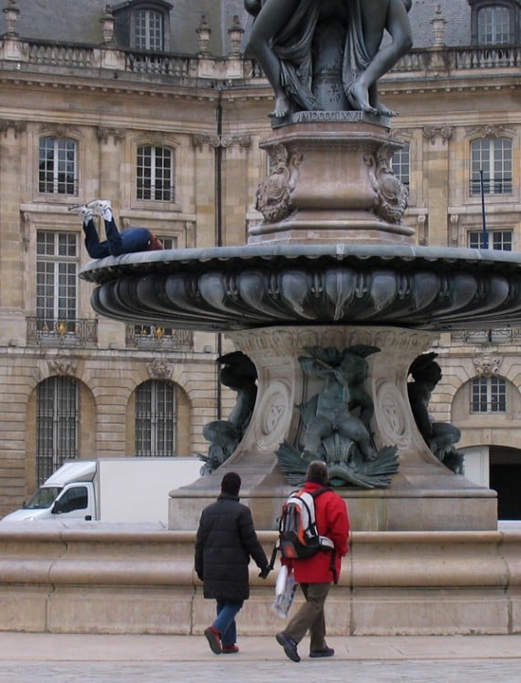 escultura sobre una fuente simulando que esta metiendo su cabeza 