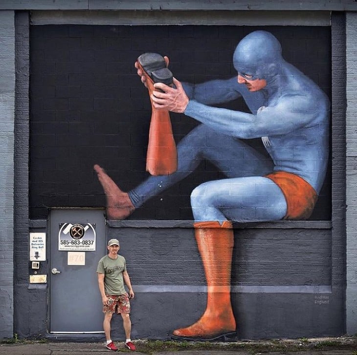 dibujo de un superhéroe quitándose una bota pintado en una pared de Rochester, NY