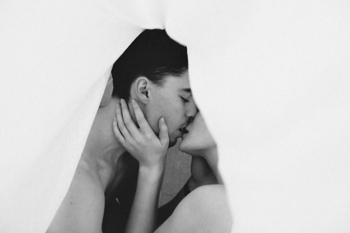 fotografía de una pareja besándose entre sabanas 