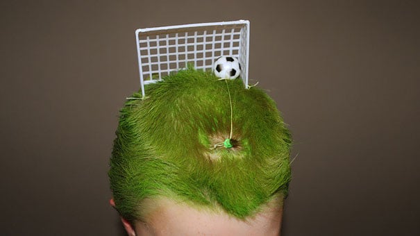 cabeza de un niño con el cabello de color verde y una portería de fútbol 