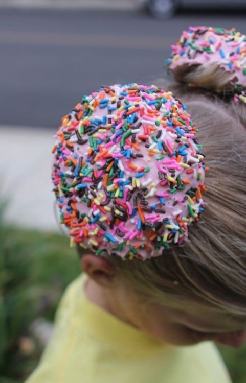 niña peinada con dos colitas de pan con chispas de colores 