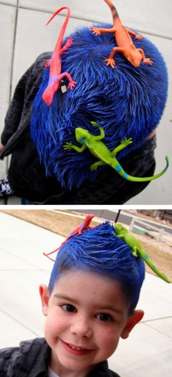 niño con el cabello de color azul y unas iguanas de juguete encima 