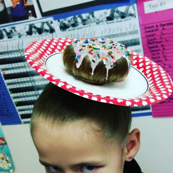 niña peinada con un plato y una dona glaseada 