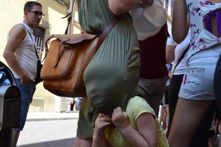 NIÑA JUGANDO EN EL VESTIDO DE LA MAMÁ