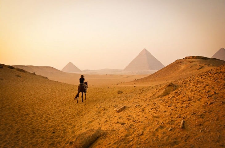 mujer en desierto admirando las piramides en Egipto