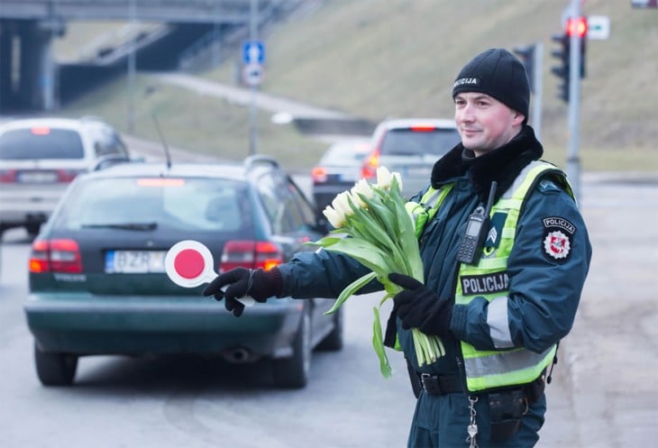 Oficial de Lituania parando el tráfico con flores en la mano 