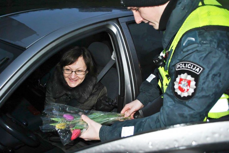 Policía regalando flores a una mujer en Lituania, Europa 